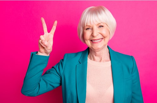 Older woman giving a peace sign with her hand